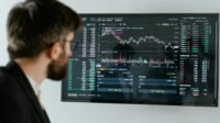 Seorang Pria Menganalisis Grafik Investasi Pemula