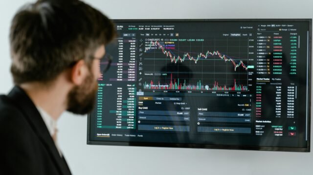 Seorang Pria Menganalisis Grafik Investasi Pemula
